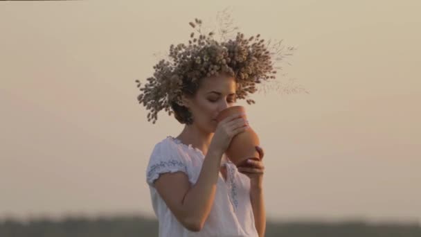 Joven hermosa chica es beber leche de una jarra en la naturaleza — Vídeos de Stock