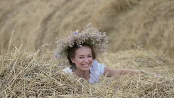 Junges Mädchen im Kranz ruht im Stroh-Heuhaufen — Stockvideo