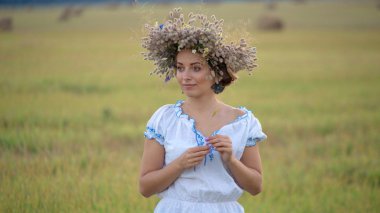 genç kız bir çelenk içinde açık bir alanda tek başına ayakta
