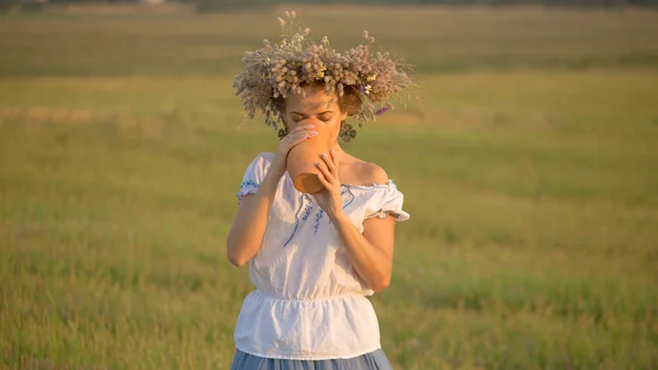 Mooi meisje is het drinken van melk van een kruik op de natuur — Stockfoto