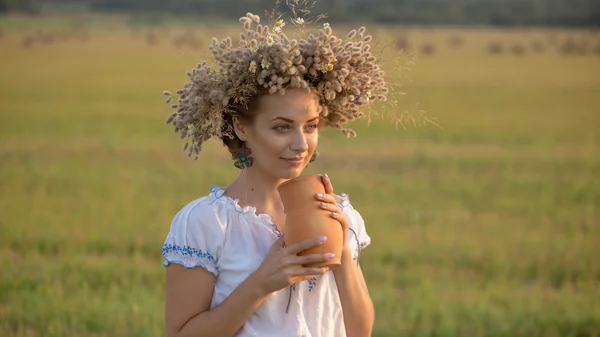 Mooi meisje is het drinken van melk van een kruik op de natuur — Stockfoto