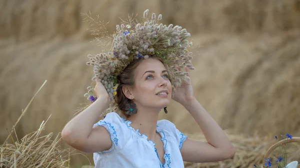 わら干し草で休んでいる花輪の少女 — ストック写真