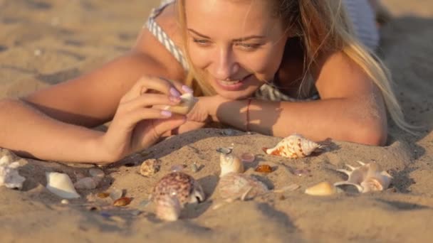 Meisje rusten op het zand in de buurt van de rivier in de avond — Stockvideo