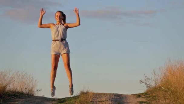 Gelukkig mooi jong meisje dansen in een veld — Stockvideo