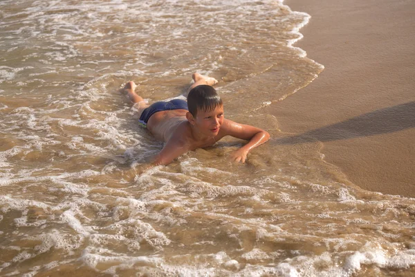 Chico frolics en el mar con salpicaduras y olas — Foto de Stock