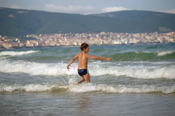 Frolics menino no mar com salpicos e ondas — Fotografia de Stock