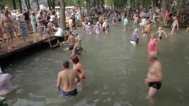 SLAVGOROD, BELARUS 14: The Blue Krynica (dalam bahasa Inggris). ziarah massal untuk penyembuhan ke Honey Spas. Orang-orang berenang ke dalam air es dan pergi ke sungai pada tradisi liburan 14 Agustus 2016 di Slavgorod, Belarus  . — Stok Video