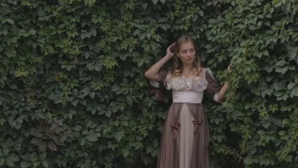 Girl on a background of green fences — Stock Video