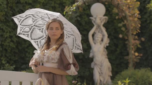 Fille avec un parapluie blanc sur le banc — Video