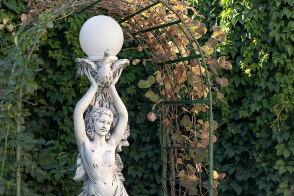 Скульптура девушки в летнем саду — стоковое фото