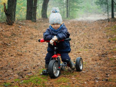 2020 model bisikletle ormanda küçük bir çocuk.