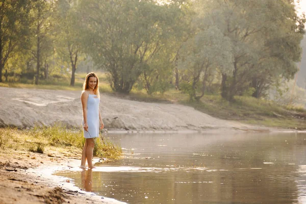 2020年の夜明けに湖の上の短いボンデージドレスの女の子 — ストック写真