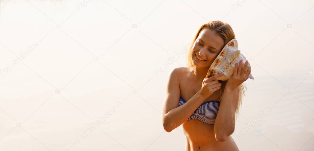 portrait of a girl with a sea shell near the water at sunrise 2020