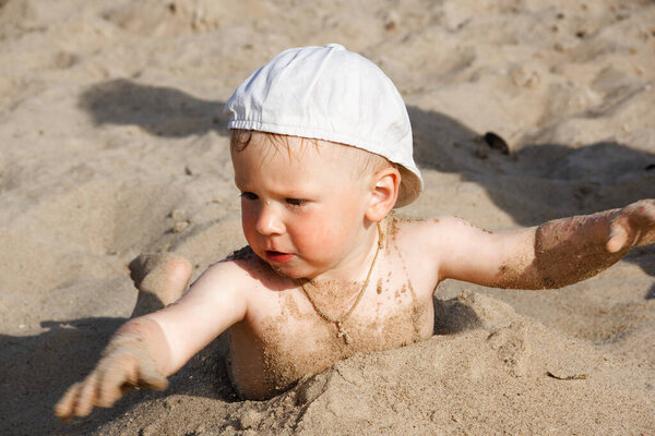 ребенок играет на пляже у воды 2020