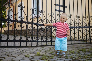 Bir çocuk dövülmüş demir ızgara 2020 ile oynuyor.