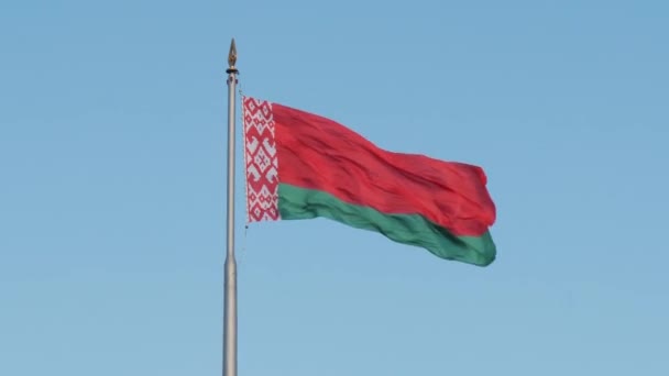Beyaz Rusya bayrağının mavi gökyüzüne karşı rüzgarda sallanan sembolleri. — Stok video
