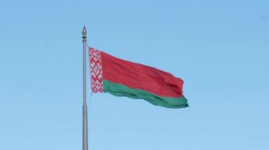 Beyaz Rusya bayrağının mavi gökyüzüne karşı rüzgarda sallanan sembolleri.