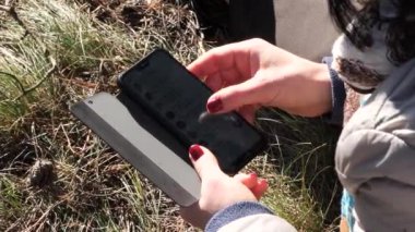 Piknikteki bir kız telefonundaki mesajlara bakar.