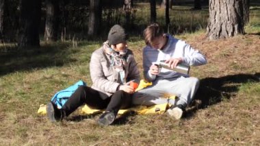 Piknik gençleri sonbaharda güneşin altında çimlere uzanır.