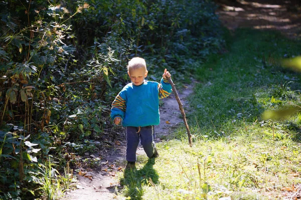 little boy walking with a cane on a country road 2020