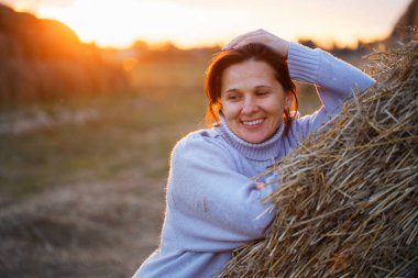 2020 'de gün batımında saman yığınında bir kız.