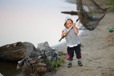 2020 numaralı balık ağıyla balık tutan küçük çocuk.