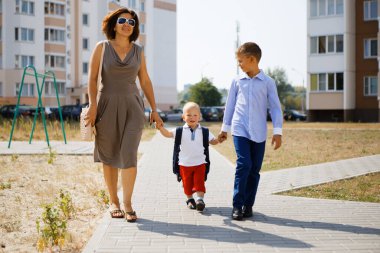 Mutlu anne çocuklarla okula gidiyor. 2020.