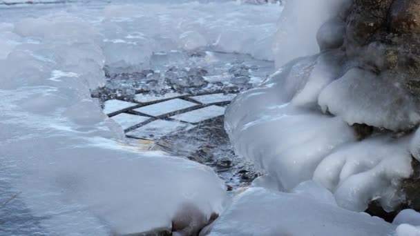 Вода льется из источника зимой и замерзает — стоковое видео