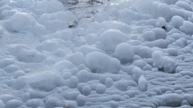 Kışın pınardan su akar ve donar.