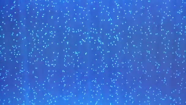 青い水の中にゆっくりと浮遊する気泡が — ストック動画