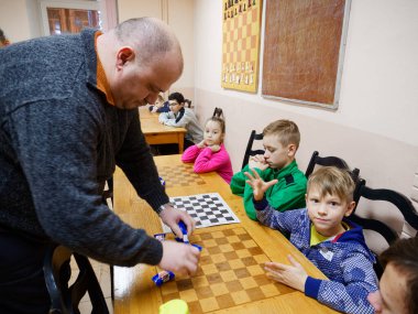 GOMEL, BELARUS - 27 Aralık 2020: Çocuklar arasında Yılbaşı Dama Turnuvası. Şeker 2020 şampiyonlarıyla eş zamanlı oyun