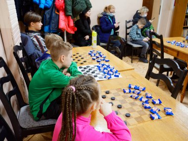 GOMEL, BELARUS - 27 Aralık 2020: Çocuklar arasında Yılbaşı Dama Turnuvası. Şeker 2020 şampiyonlarıyla eş zamanlı oyun