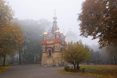 GOMEL, BELARUS - 23 EKİM 2015: Sonbaharda sis içinde şehir parkı. Rumyantsev sarayı mimarisi 2021