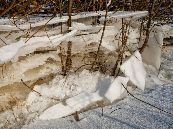 broken ice near the river bank in the cold. lower water levels break ice 2021