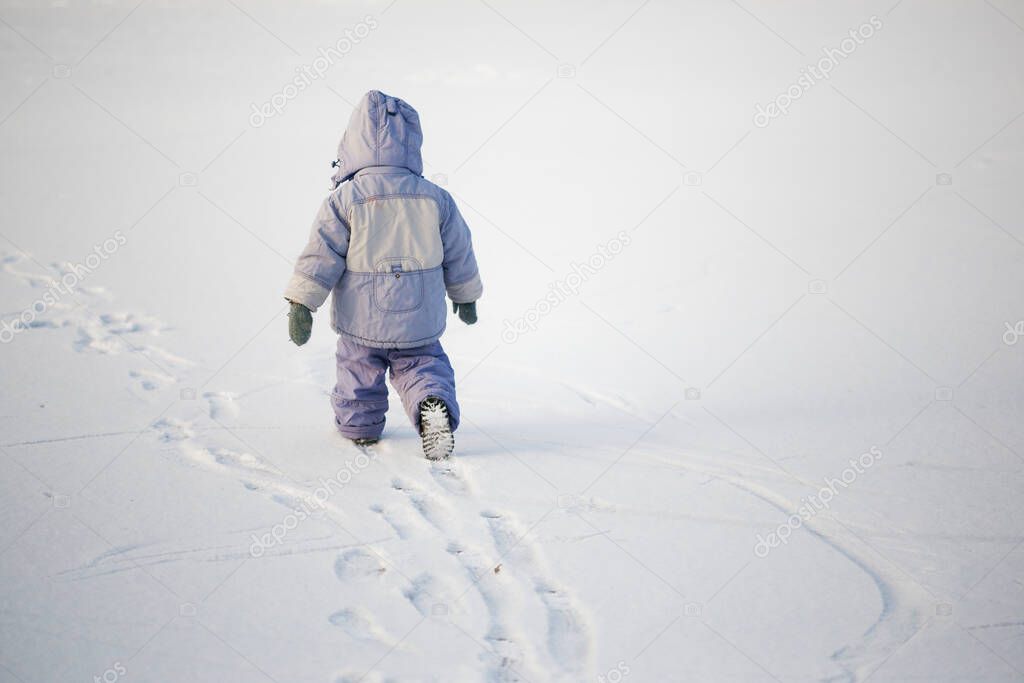 little lonely boy in winter on ice in the snow 2020