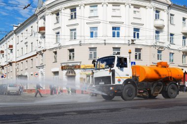 GOMEL, BELARUS - 4 Mayıs 2016: Sıcak havada şehrin sokaklarını sulama makinesi
