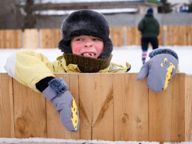 2021 'de şapkalı ve eldivenli dişsiz bir çocuğun portresi.