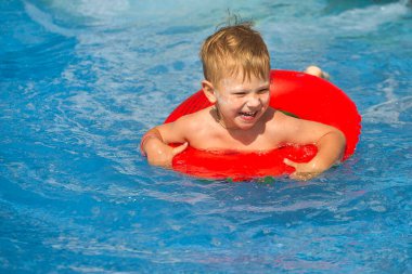 Çocuklar mavi suyu olan bir havuzda yüzerler 2021