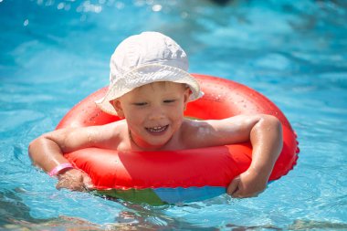 Çocuklar mavi suyu olan bir havuzda yüzerler 2021