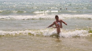 Aile 2021 plajında deniz dalgalarında yüzer.