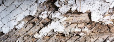 Köy evinin eski, çatlak alçısını..