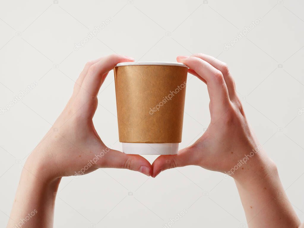 disposable coffee paper eco friendly cup in hand isolated on white background 2021