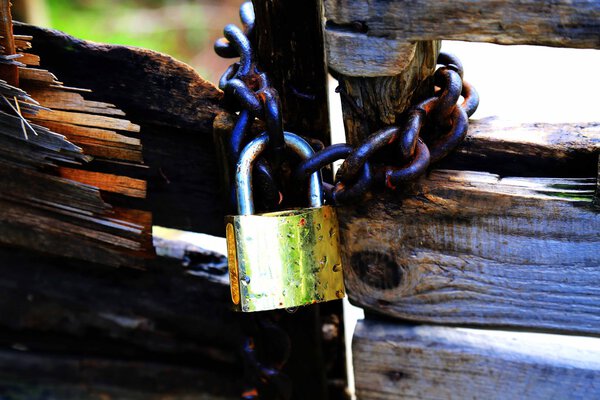 Запирать гнилую деревянную дверь со старым замком и цепью
