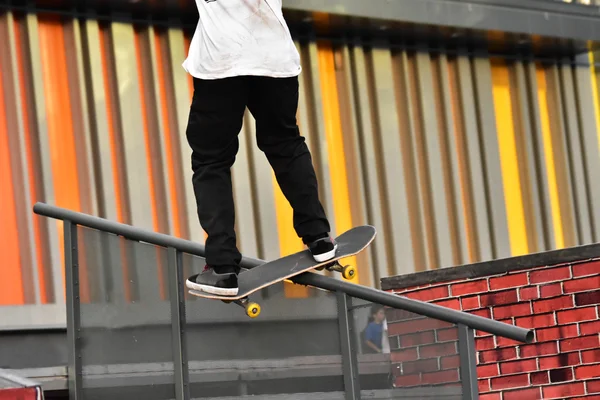 Skateboarding como deporte extremo y divertido. Skateboarder haciendo un truco en un parque de skate de la ciudad . — Foto de Stock
