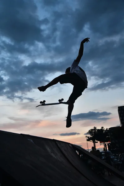 Skate como esporte extremo e divertido. Skateboarder fazendo um truque em um parque de skate da cidade . — Fotografia de Stock