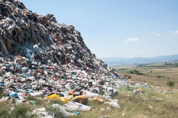 Landfill near crop fields and small city. Enormous Trash wave near fields — Stock Photo, Image