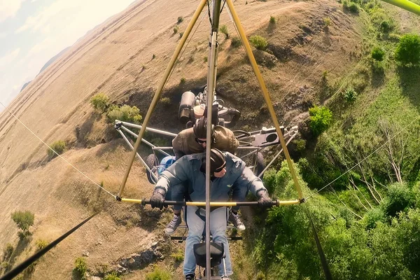 Hang Glider tandem alanları ve ormanları uçan. Eğlenceli ve aşırı spor olarak kayma asmak. — Stok fotoğraf