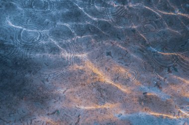 Güneşli bir günde eski bir çeşmenin su yüzeyi. Soyut sıvı arkaplan