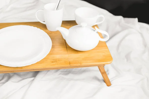 tray with tea in bed