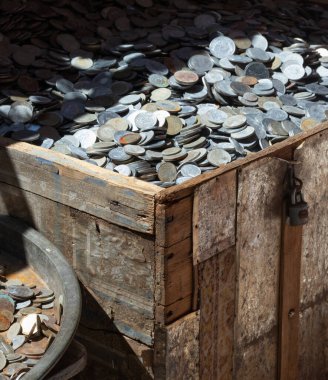 Hazine sandığı farklı paralarla dolu. Yakın plan fotoğraf..